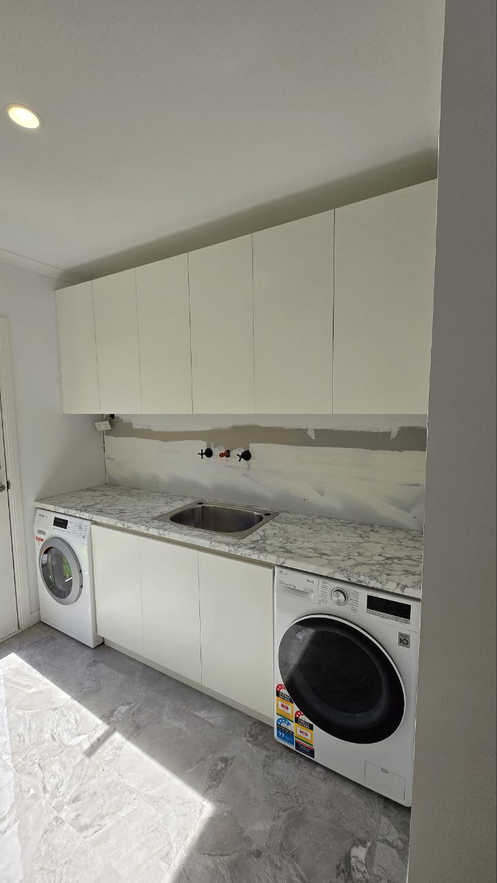 Completed laundry with full-height custom cabinetry
